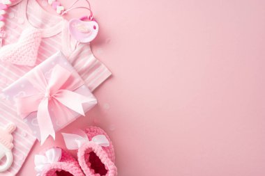 A pink-themed baby shower gift set, including clothes, knitted heart, pacifier, rattle, and a gift box with a ribbon clipart