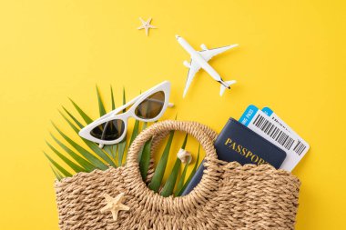 Yaz seyahatinin temel gereksinimleri güneş gözlüğü, pasaport ve sarı arka planda biniş kartları.