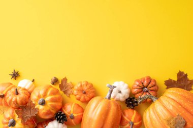 A variety of pumpkins and autumn leaves scattered on a bright yellow background, evoking the fall season and Thanksgiving celebrations clipart