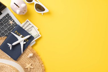 Yaz seyahati gereklilikleri arasında dizüstü bilgisayar, pasaport, para, güneş gözlüğü ve parlak sarı arka planda domuz kumbarası da var.