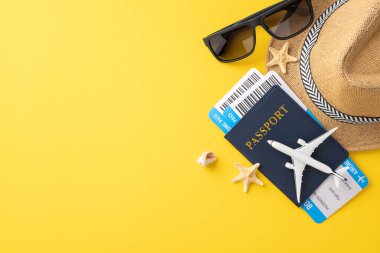 Pasaport, uçak modeli, güneş gözlüğü ve deniz yıldızının sarı arka planda olduğu düz bir yaz seyahati.
