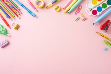 Pembe arka planda renkli okul kırtasiyeleri var. Okul temaları ve eğitim projeleri için ideal