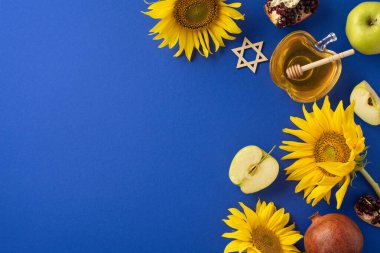 Mavi arka planda bal, ayçiçeği, elma ve Davut Yıldızı 'nın yer aldığı şenlikli Rosh Hashanah düzenlemesi