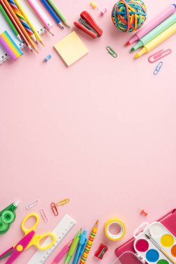 Pembe arka planda çeşitli okul kırtasiyelerinin üst dikey görüntüsü. Okula ya da sınıfa dönüş teması için mükemmel