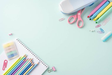 Renkli okul kırtasiyesi öğeleri hafif pastel arka plan üzerinde not defterleri, kalemler ve makas içerir