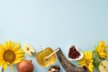Ballı, elma dilimli, nar tohumlu, ayçiçekli ve mavi arkaplanlı Rosh Hashanah bayramı konsepti