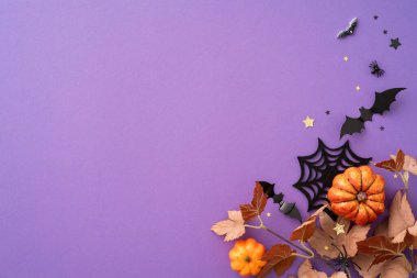 Cadılar Bayramı temalı arka planda mor bir yüzey üzerinde balkabakları, yarasalar ve örümcek ağı süslemeleri yer alıyor