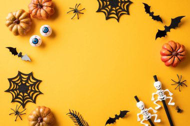 Cadılar Bayramı temalı arka planda balkabakları, yarasalar, örümcek ağları, iskeletler ve canlı sarı bir yüzey üzerindeki yenilikçi gözler yer alıyor.