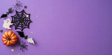 Cadılar Bayramı arkaplanı, balkabağı, örümcek ağı, hayalet, yarasalar ve yıldızlı mor zemin, neşeli bir atmosfer yaratıyor.