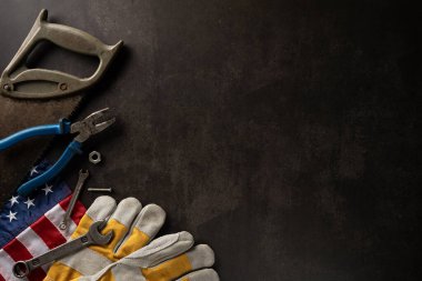 Amerika 'da İşçi Bayramı' nı temsil eden siyah arka planda düz bir alet ve Amerikan bayrağı.