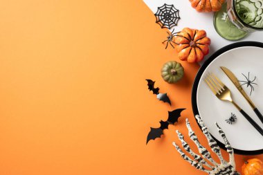 Cadılar Bayramı sofrasında balkabakları, örümcek ağları, iskelet bir el ve şenlikli bir atmosfer için yarasa süslemeleri var.