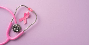 Pastel arka planda pembe steteskop ve kurdele göğüs kanseri farkındalığını ve sağlık desteğini temsil ediyor.
