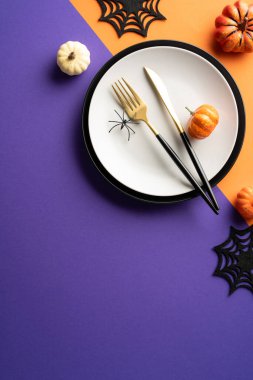 Balkabakları, siyah örümcekler ve gotik süslemelerle süslü bir Cadılar Bayramı sofrası. Tatil kutlamaları ve temalı partiler için mükemmel.