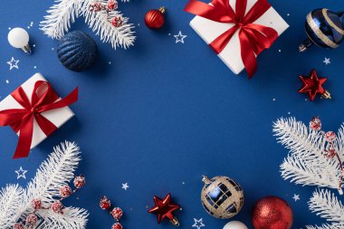 Zarif bir Noel sahnesi. Mavi arka planda güzel paketlenmiş hediyeler, süsler ve beyaz çam dalları var. Bayram kutlamaları, bayramlık kutlamalar ve mevsimlik dekorlar için mükemmel.