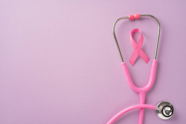 Pink stethoscope and pink ribbon symbolizing breast cancer awareness on a soft pink background, representing health care and support