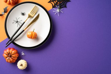 Balkabakları, örümcekler ve renkli süslemelerle dolu Cadılar Bayramı sofrası ürkütücü ve eğlenceli bir ortam yaratıyor.