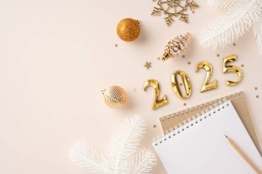 2025 altın sayı, şenlikli süsler ve yeni yıl kararlarını ve kutlamalarını simgeleyen boş bir defter içeren şık bir düzenleme.
