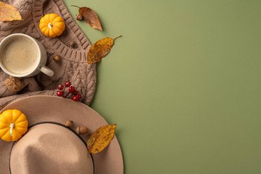 Konforlu bir süveter, dekoratif balkabakları, bir şapka ve düşen yapraklardan oluşan ılık bir sonbahar düzeneği mevsimsel bir hava yaratıyor.