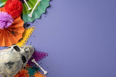 Meksika Ölüler Günü için şenlik düzenlemesi. İçinde bir kafatası, canlı kağıt çiçekler ve renkli bir manzara var. Kutlama atmosferi yaratıyor.