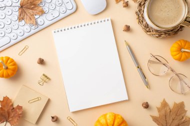Boş bir defter, kahve fincanı, mini balkabağı ve klavye içeren sonbahar temalı bir çalışma alanının düz uzantısı