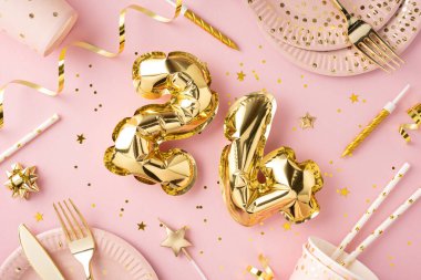 Parlak altın sayı balonları ve pembe parti süslemelerinin yer aldığı, neşeli ve unutulmaz bir kutlama atmosferi için mükemmel bir doğum günü düzeneği.