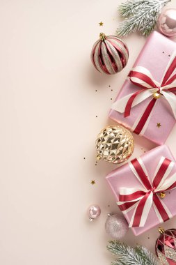 Pembe ambalajlı hediyeler ve zarif süsler içeren güzel bir dikey sahne. Bu şenlikli kompozisyon, Noel sezonunun neşeli ruhunu somutlaştıran kurdeleler, mücevherler ve yeşilliği içeriyor.