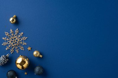 A collection of gold Christmas ornaments displayed against a deep blue background, featuring a decorative snowflake and stars. Perfect for festive, elegant holiday themes