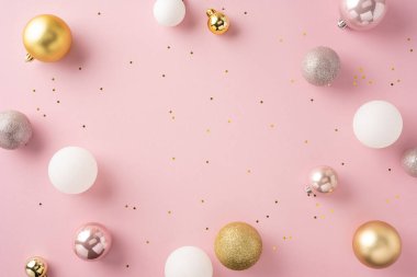 Pembe bir zemin üzerinde altın, beyaz ve pembe Noel mücevherlerinin şık bir düzenlenmesi şenlikli bir atmosfer yaratır. Bayram kutlamaları ve yeni yıl kutlamaları için ideal.
