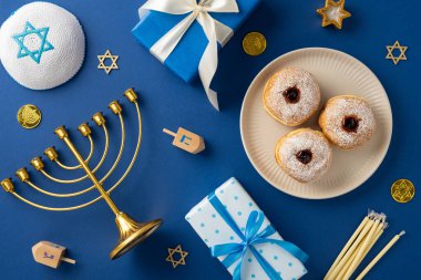 A top view of a Hanukkah celebration scene with a menorah, gifts, dreidels, and traditional donuts on a blue surface. clipart