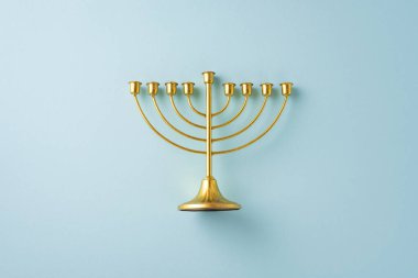 A beautifully crafted gold menorah with a clean minimalist design set against a pastel background, symbolizing the Hanukkah celebration clipart