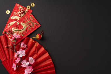 Altın desenli kırmızı zarflar, sikkeler, geleneksel bir hayran ve kiraz çiçekleri Çin 'in yeni yıl kutlamalarını ve refahını simgeliyor.