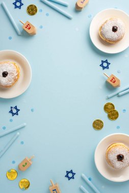 A top vertical view of a Hanukkah celebration setup with traditional donuts, dreidels, and gold coins on a blue background. Perfect for festive and cultural themes clipart