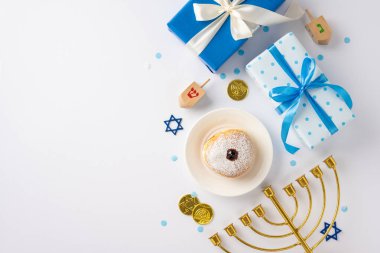 Top view of Hanukkah gifts, dreidel, menorah, and festive doughnut on a light background creating a joyful holiday atmosphere clipart