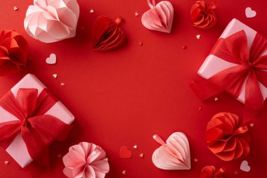 Aşk temalı tasarımlar için mükemmel kırmızı bir zemin üzerinde kalp şeklinde dekorasyonlarla çevrili kırmızı ve pembe hediyeler içeren romantik bir Sevgililer Günü sahnesi.