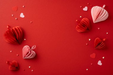 Güzel kağıt kalpler, canlı kırmızı bir arka planda, sevgililer günü kutlamalarında aşk ve romantizmi simgeleyen sanatsal bir şekilde düzenlenmiştir.