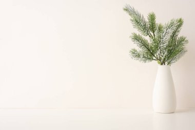 Minimalist İskandinav estetiği ile şekillendirilmiş, çam ağacından dallar tutan basit bir vazo. Kış ya da Noel temalı dekorasyon için mükemmel. Her yere biraz doğa ve zarafet katıyor.
