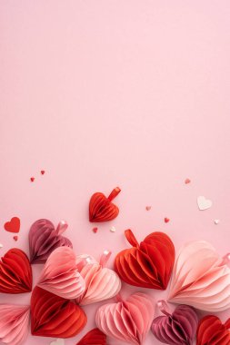 Kırmızının ve pembenin tonlarında kalp şeklinde dikey kağıt süslemeler aşk ve romantizmi çağrıştırıyor.