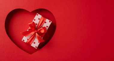 Sevgi ve sevgiyi sembolize eden kırmızı kurdeleli güzel bir hediye kutusu. Sevgililer Günü, yıldönümleri ya da romantik kutlamalar için mükemmel.