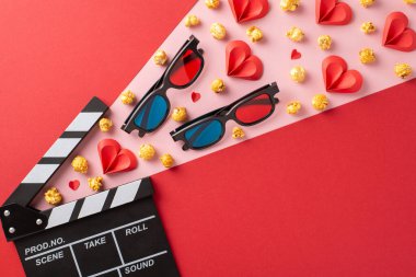 Üç boyutlu gözlük, patlamış mısır ve kalp şekilli yaratıcı sevgililer günü sahnesi. Randevu gecesi, romantizm ve sinema temaları için ideal.