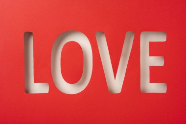 Görsel olarak çarpıcı bir görüntü, 'Aşk' kelimesinin yaratıcı bir şekilde kırmızı arka planda kesilmesi, romantizmi ve sevgiyi sembolize ediyor. Sevgililer Günü promosyonları ve romantik tasarımlar için ideal.