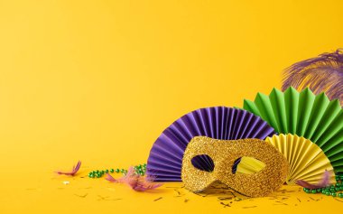 Mardi Gras temalı yan manzara kutlaması renkli dekorasyonlar, parlak bir maske, kağıt yelpaze ve şenlikli boncuklar.