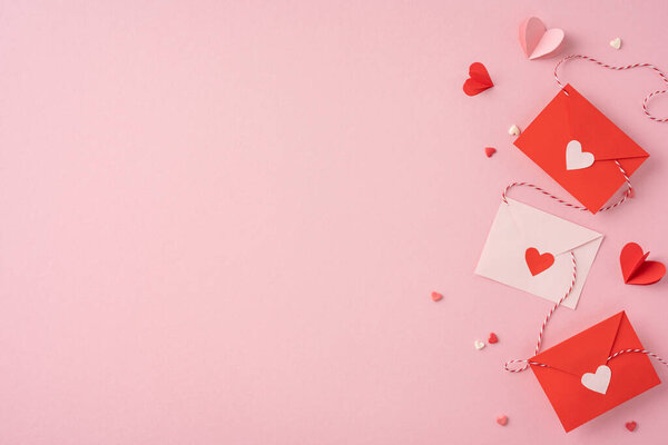 Три красно-белых конверта с украшениями сердца и бумажными сердцами на светло-розовом фоне, вызывающие романтические чувства