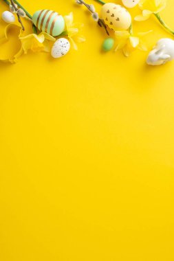 Renkli yumurtalar, tavşan heykelcikler ve sarı arka planda bahar çiçekleri içeren Paskalya dikey konsepti