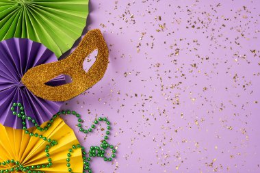 Gösterişli maskeler, renkli boncuklar, dekoratif kağıtlar ve konfeti süsleri, ışık saçan kutlama ve karnaval atmosferi içeren Mardi Gras kompozisyonu