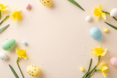 Paskalya temalı daire rengarenk boyalı yumurtalar ve parlak nergisler yumuşak bir pastel yüzeyde düzenlenerek neşeli ve neşeli bir tatil havası yaratıyor.