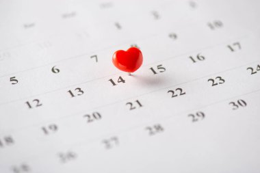Takvimin 14 numarasına, Sevgililer Günü 'nü sembolize eden kırmızı bir kalp şeklinde iğne konur.