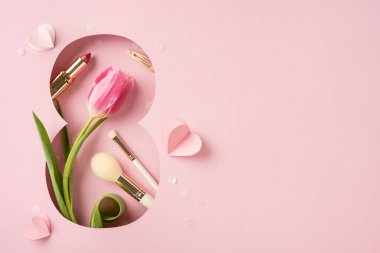 Dişiliği lale, makyaj ve pembe bir düzende kağıt kalple kutluyoruz.