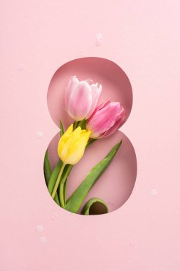 Pembe ve sarı lalelerin dikey, parlak bir kombinasyonu.