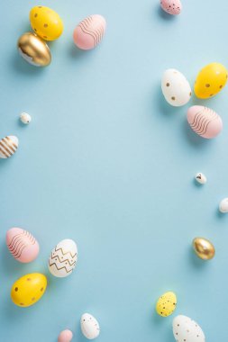 Renkli dikey paskalya yumurtaları mavi bir yüzeye yerleştirilmiş.