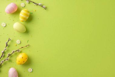 Renkli yumurtalar, çiçek dalları ve taze yeşil arka planlı Paskalya temalı düzenleme. Baharı ve Paskalya kutlamalarını kutlamak için mükemmel.